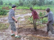 Dennis shows Ryan where to start planting in the orchard.
